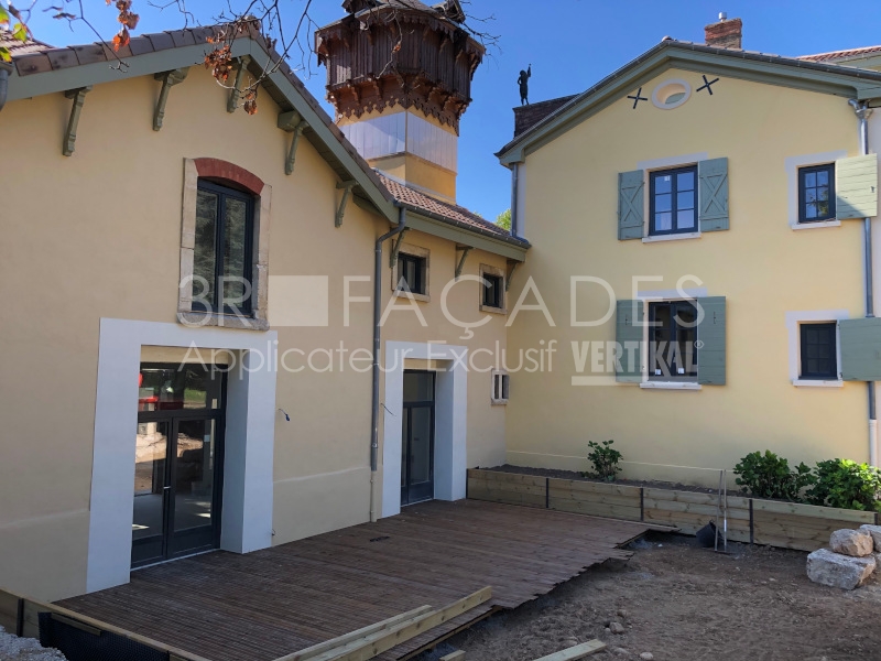 Maison jaune avec 3R Façades fenêtres vertes et portes.