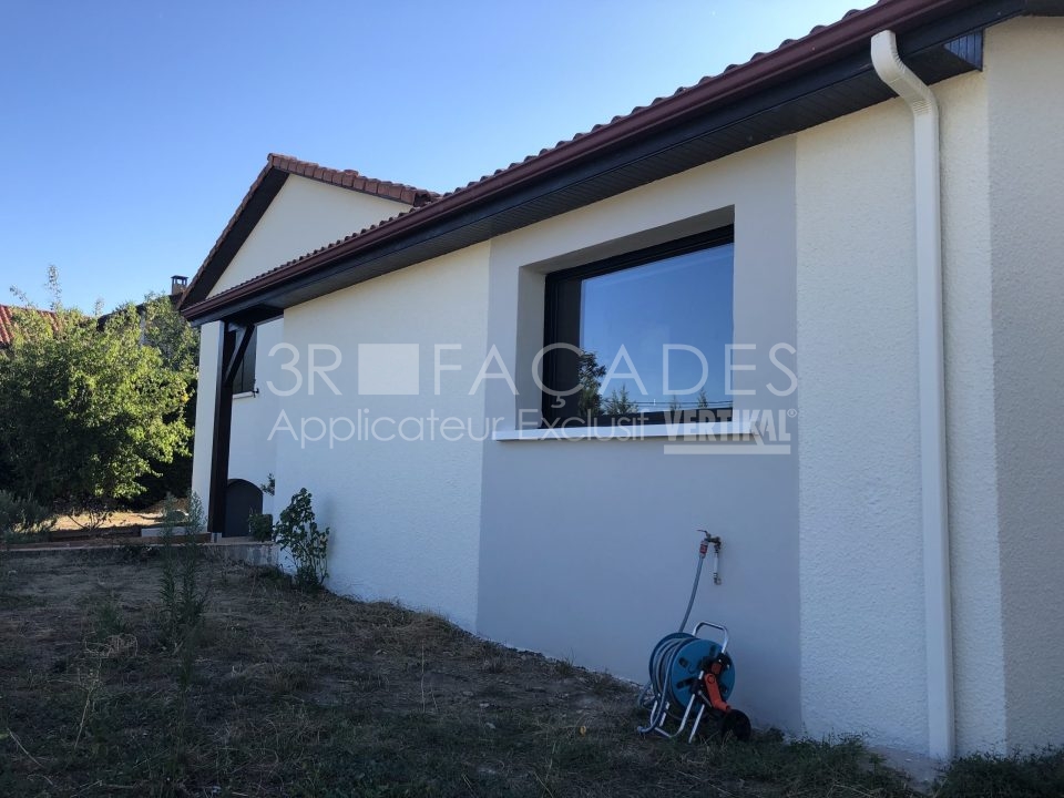 Maison blanche avec fenêtre et tuyau d'arrosage.