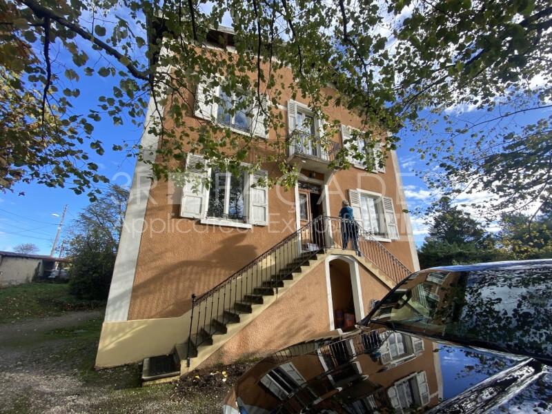 Maison peinte orange avec escalier et balcon.