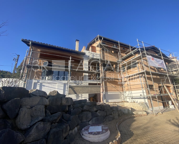 Construction en cours, façade en bois, échafaudages, rénovation.