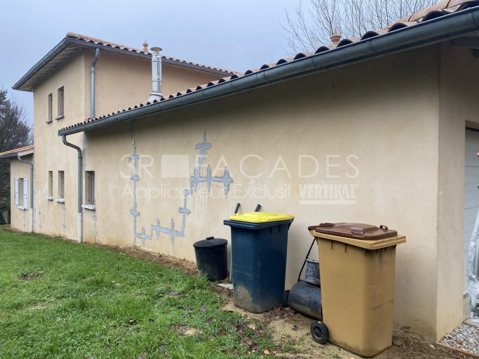 Façades 3R : Bacs à ordures contre un mur de maison.