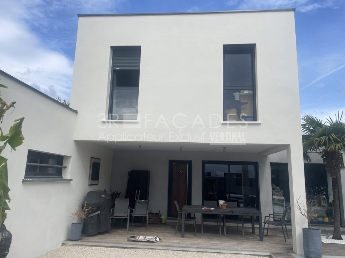 Maison moderne avec patio et mobilier de jardin.