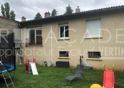 Jardin avec jouets et meubles, façade de maison.