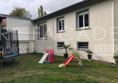 Jardin de maison avec toboggan et trampoline.